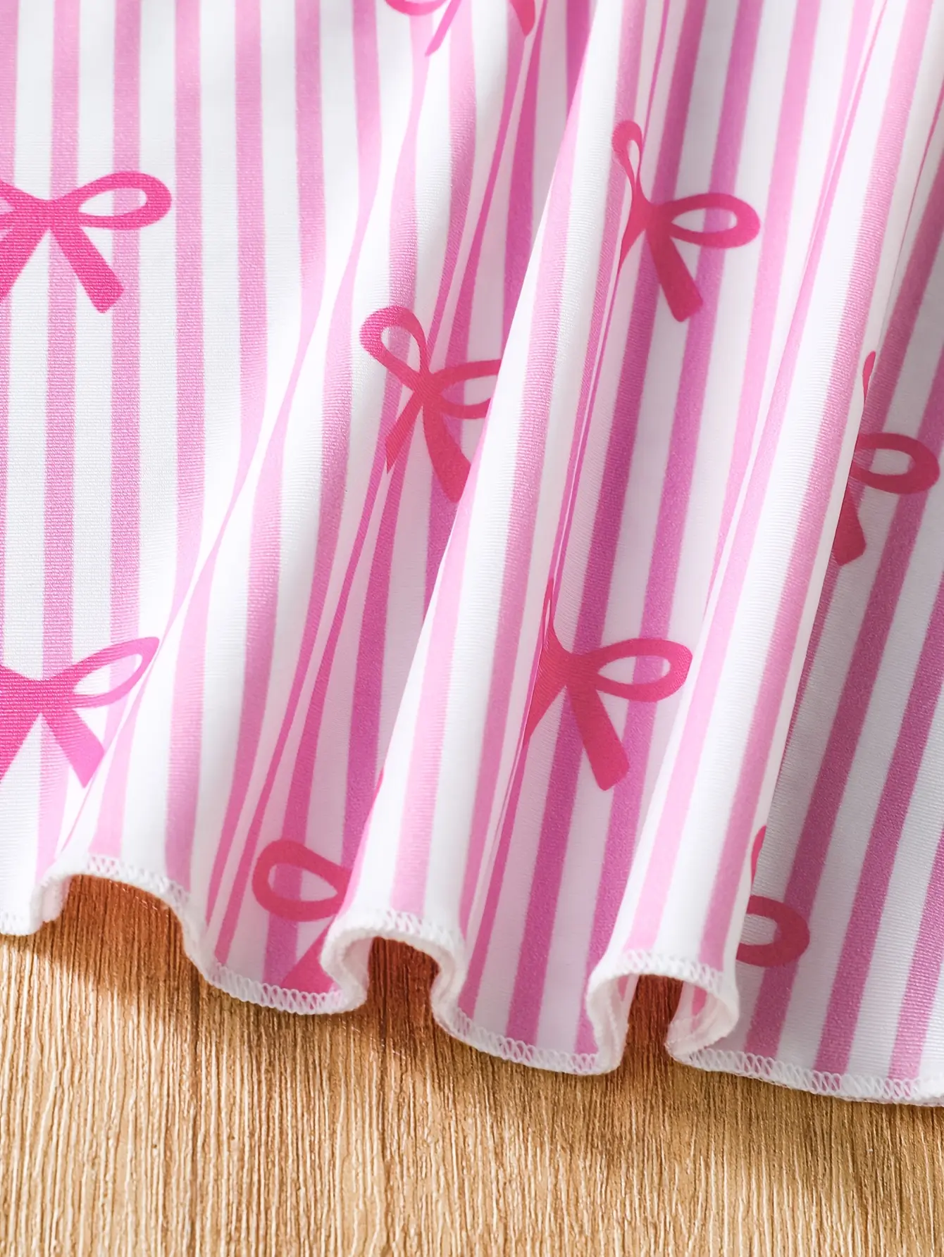 Detail view of Girls Pink Bow Stripe One-Piece Swimsuit with Skirt by LUNORIANA