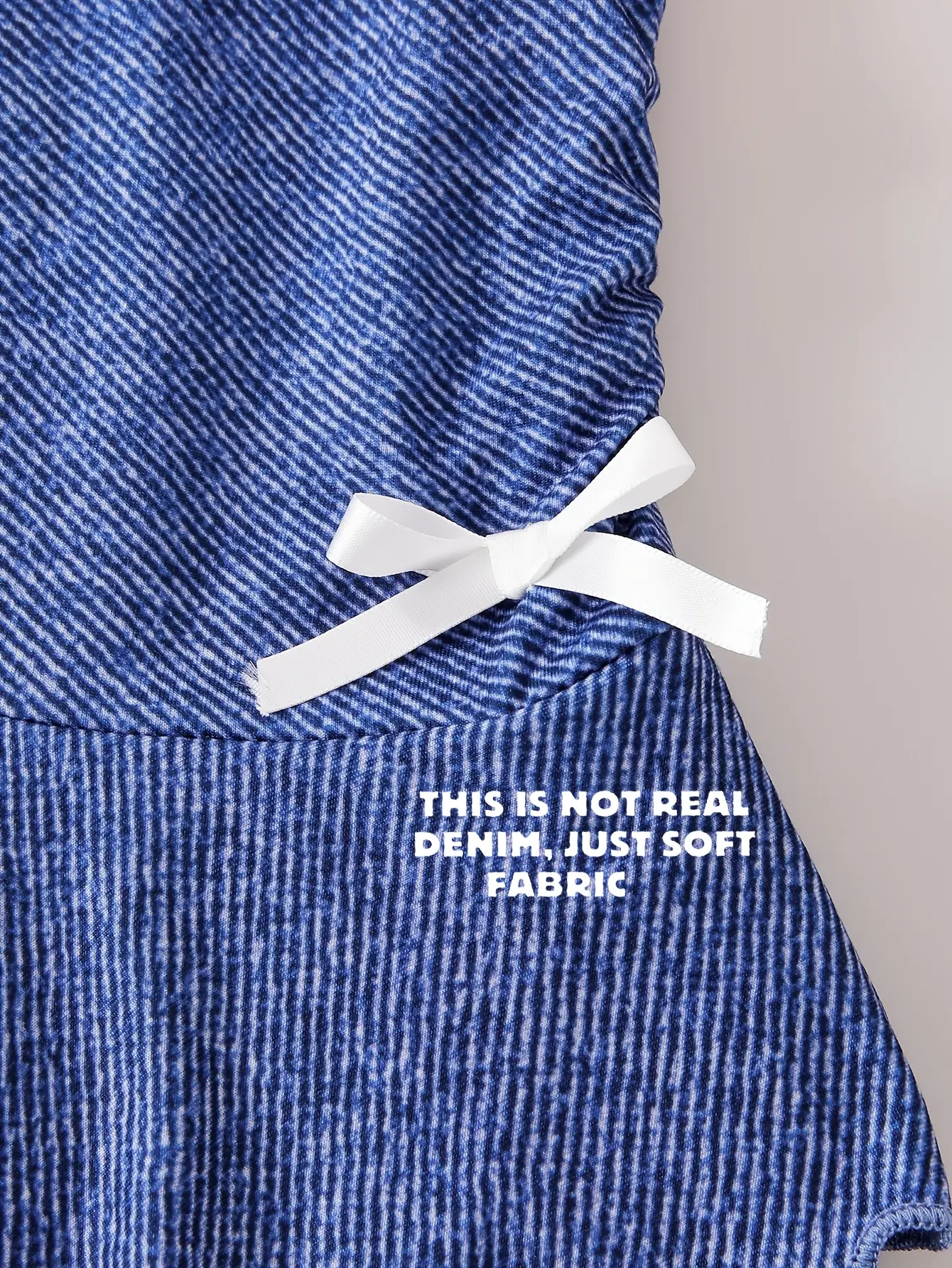 Detail view of Girls Denim Print Tiered Ruffle Dress with Bow Detail by LUNORIANA