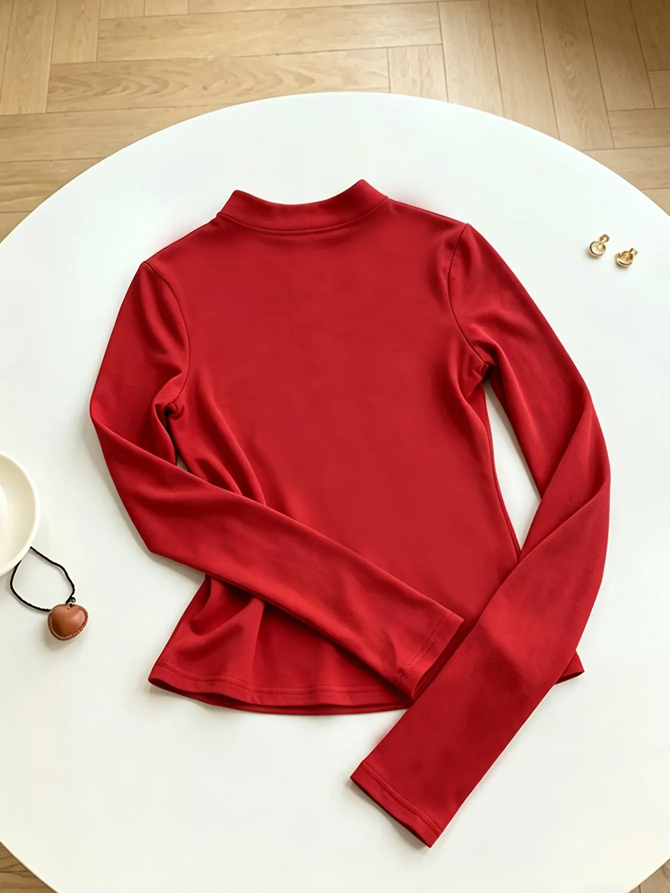 Women’s red mandarin-collar top with gold frog closures flat lay