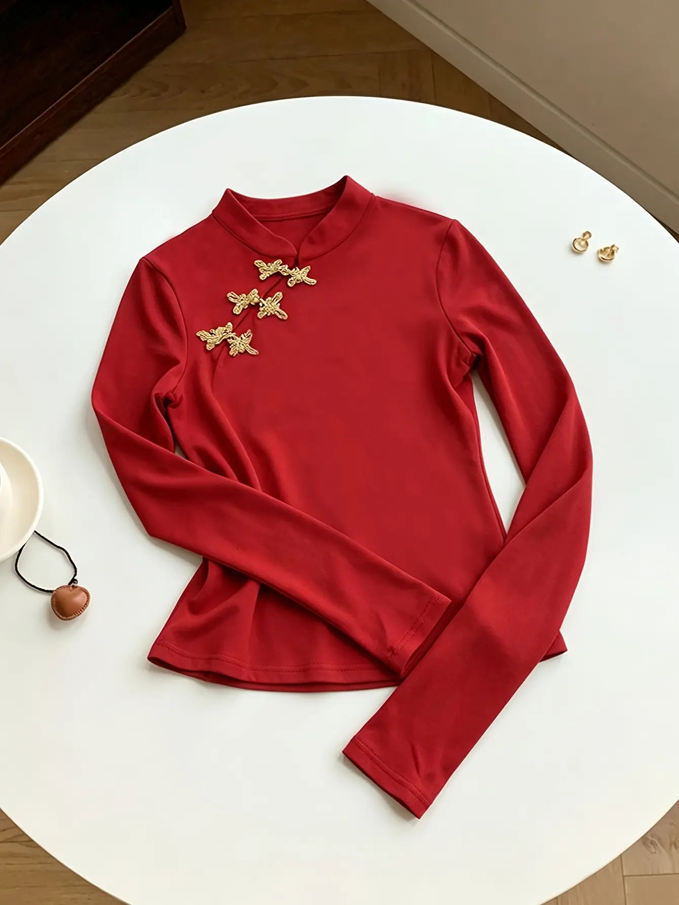 Women’s red mandarin-collar top with gold frog closures detail