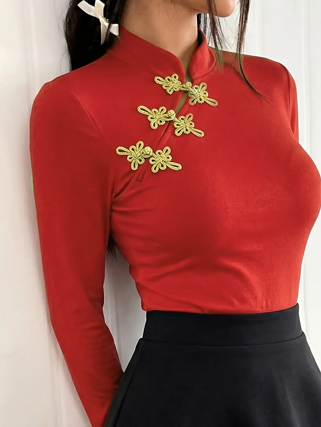 Women’s red mandarin-collar top with gold frog closures close-up