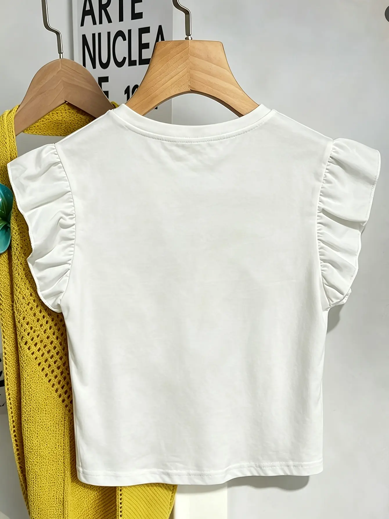 White ruffle-sleeve top with floral applique