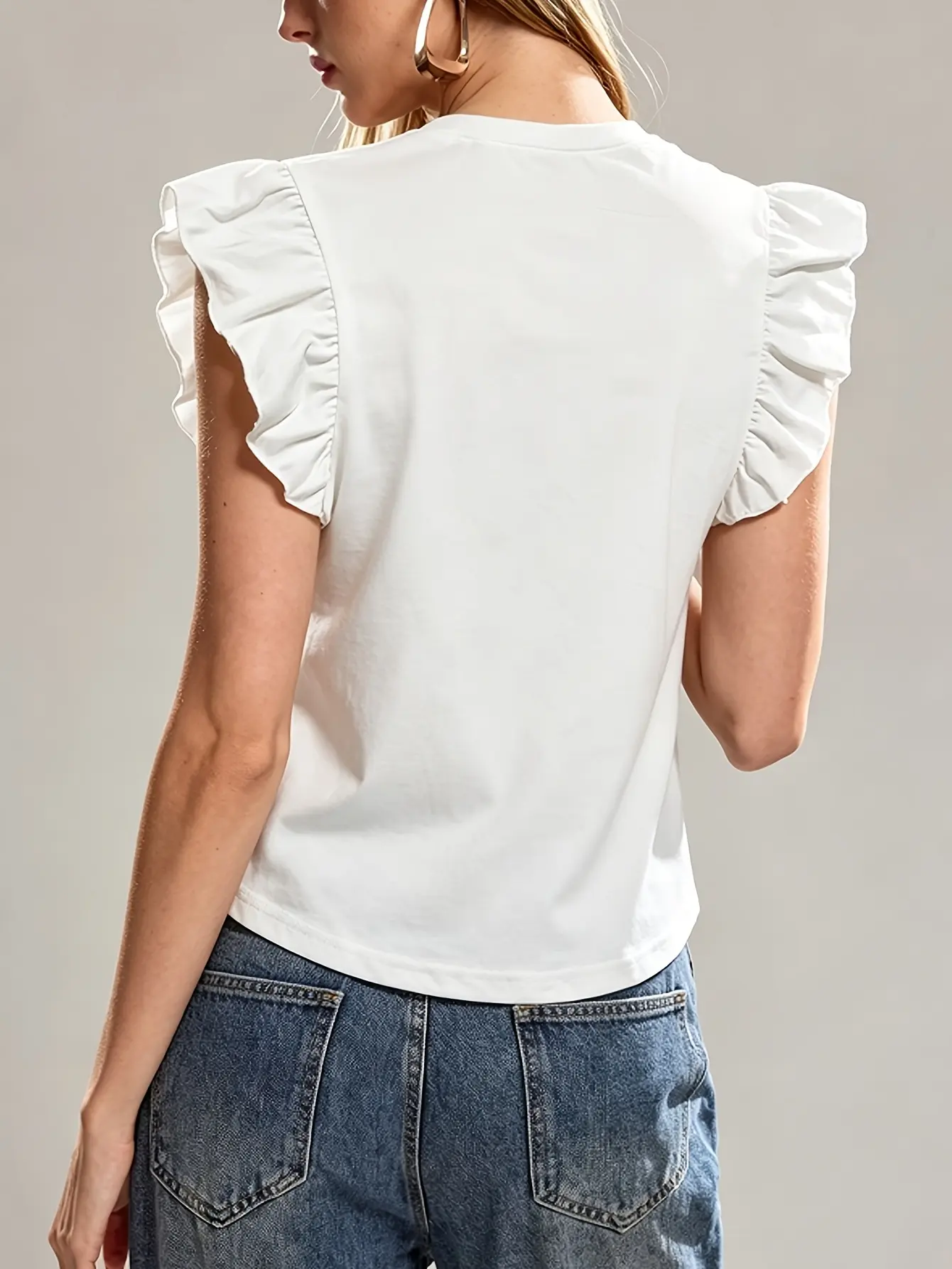 Back view of white ruffle-sleeve floral applique top