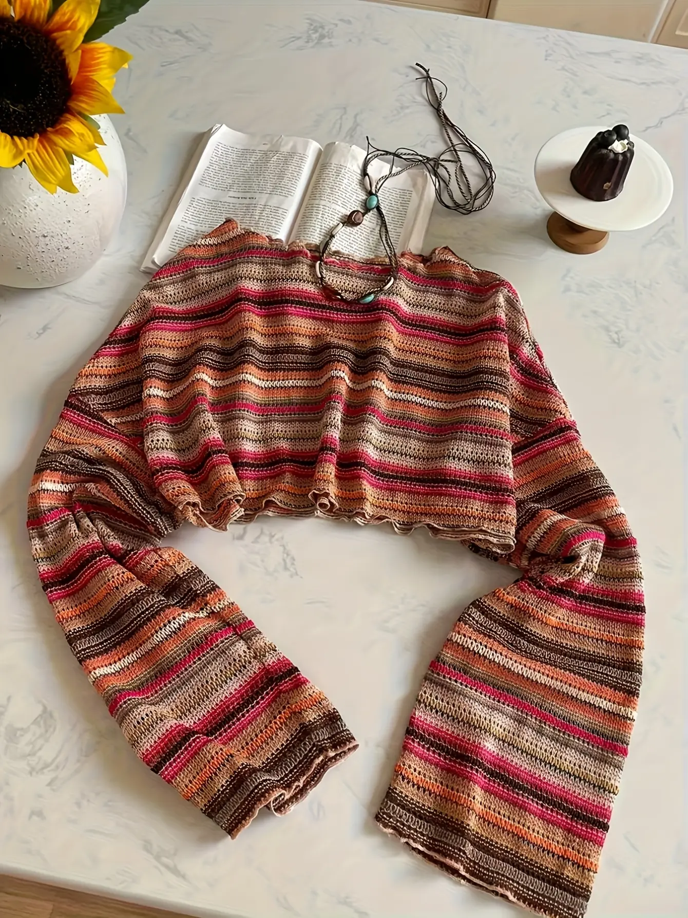 Multicolored striped crochet-knit bell-sleeve top laid flat