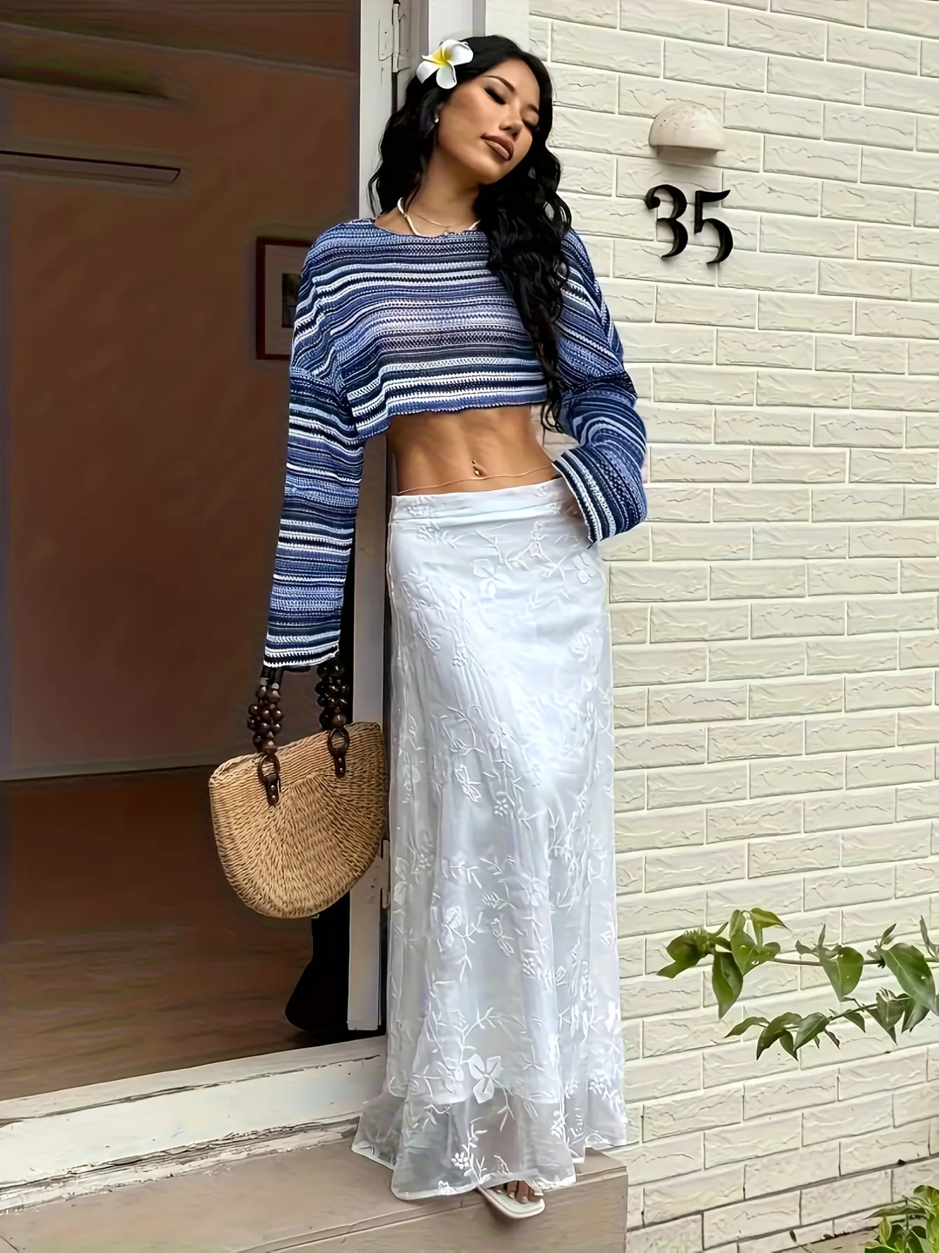 Model wearing blue striped crochet-knit bell-sleeve top