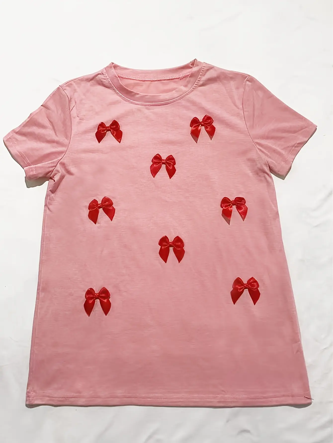 Pink crew-neck T-shirt with red bow appliques