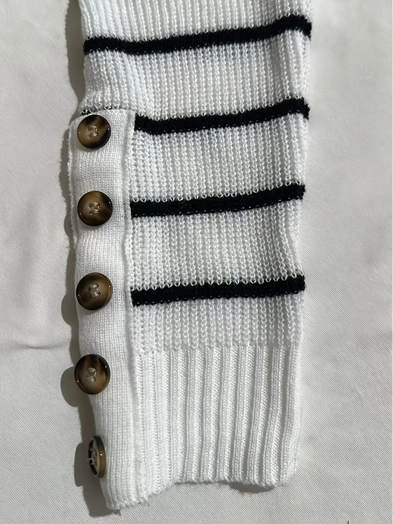 Close-up of white striped knit set with button detail