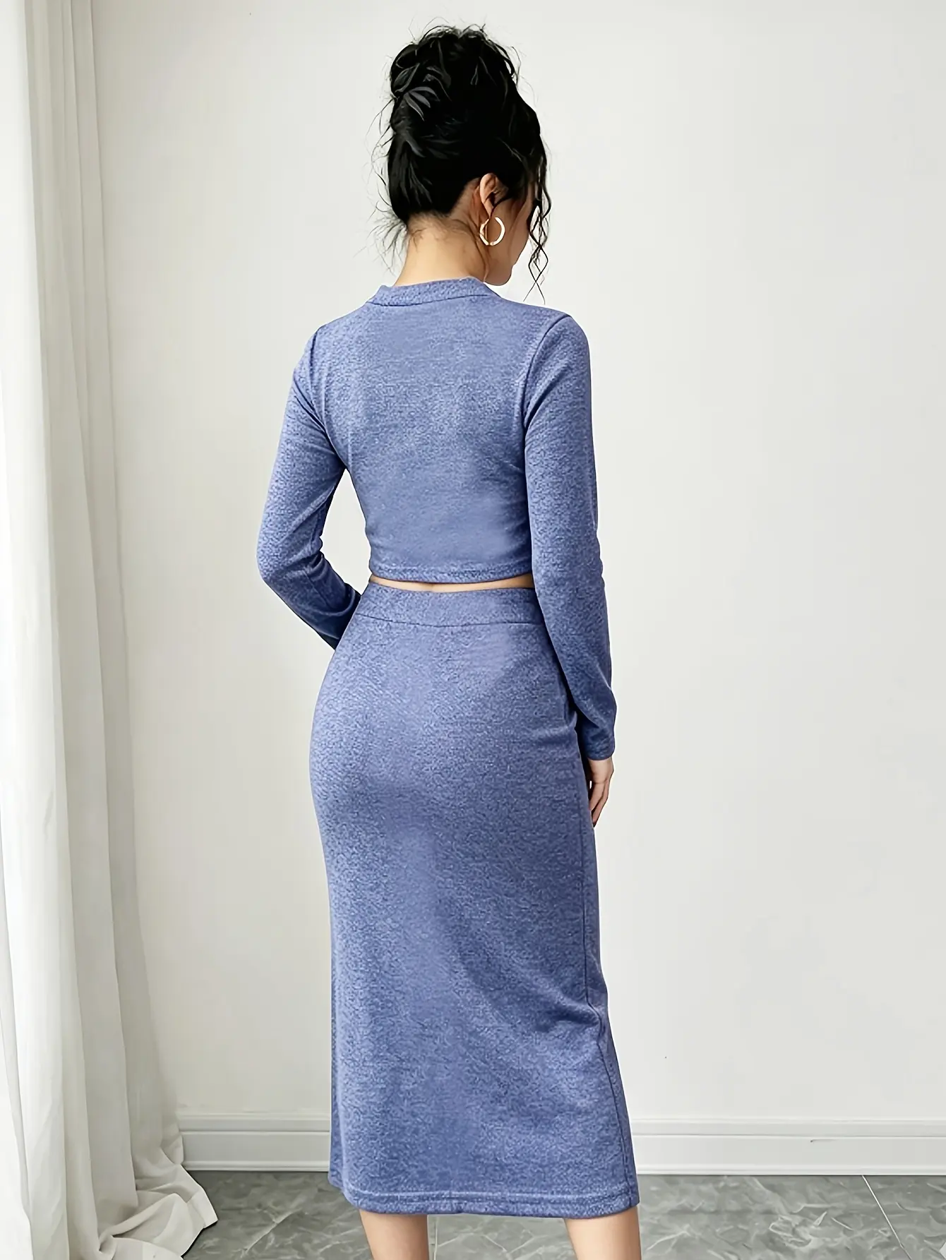 Back view of blue mock-neck crop top and slit midi skirt