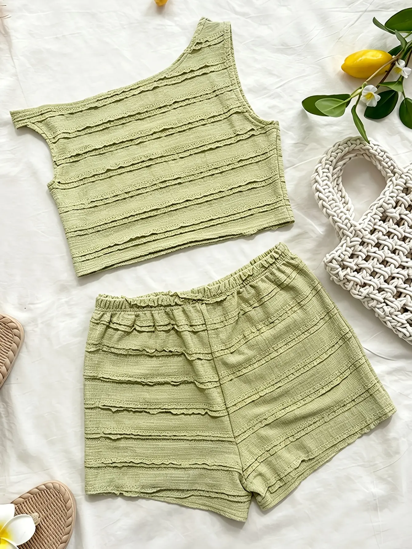 Green asymmetric knit top and shorts set laid flat